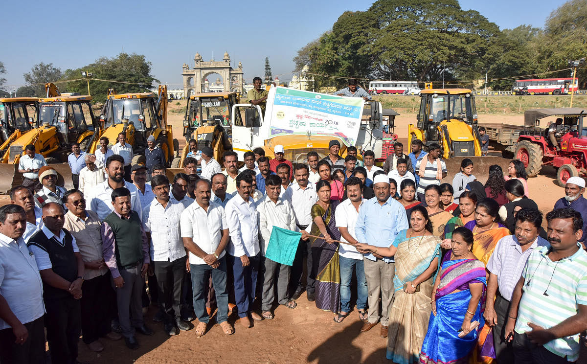 Mayor Pushpalatha Jagannath inaugurates the clean-up campaign, organised by MCC on Dasara Exhibition Grounds, in Mysuru on Thursday. MCC Commissioner K H Jagadeesh and Deputy Mayor Shafi Ahmed are seen. DH PHOTO