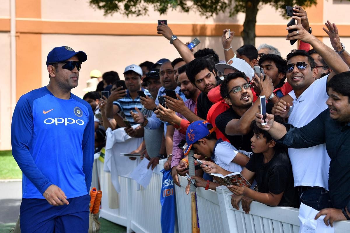 FOREVER, A STAR: Fans take selfies with India's Mahendra Singh Dhoni (left) prior to the team's training session in Sydney on Friday. AFP