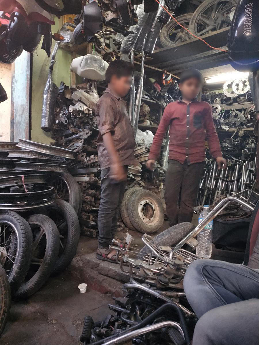The street, near Russell Market, is lined with shops selling spares taken from old and discarded vehicles. (Right) Child workers are common.