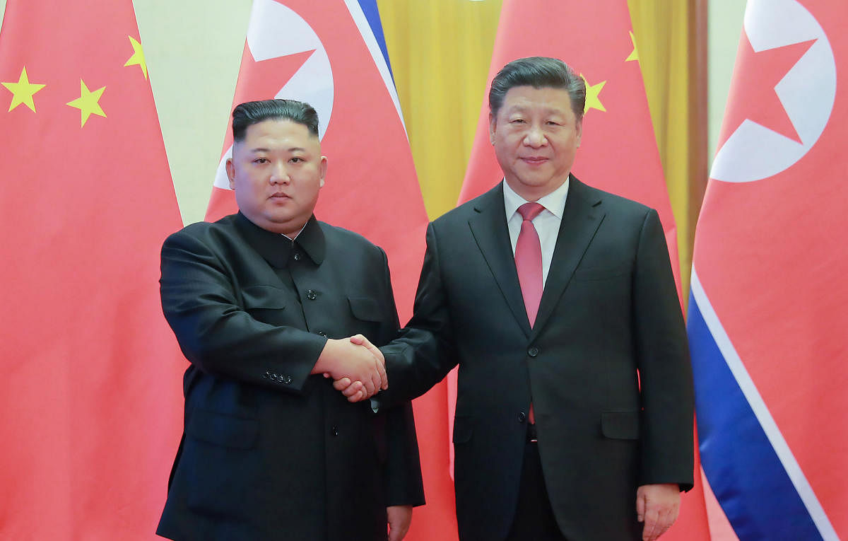 This January 8, 2019 picture released by North Korea's official Korean Central News Agency (KCNA) on January 10 shows North Korea's leader Kim Jong Un (L) shaking hands with China's President Xi Jinping (R) during a welcome ceremony at the Great Hall of t