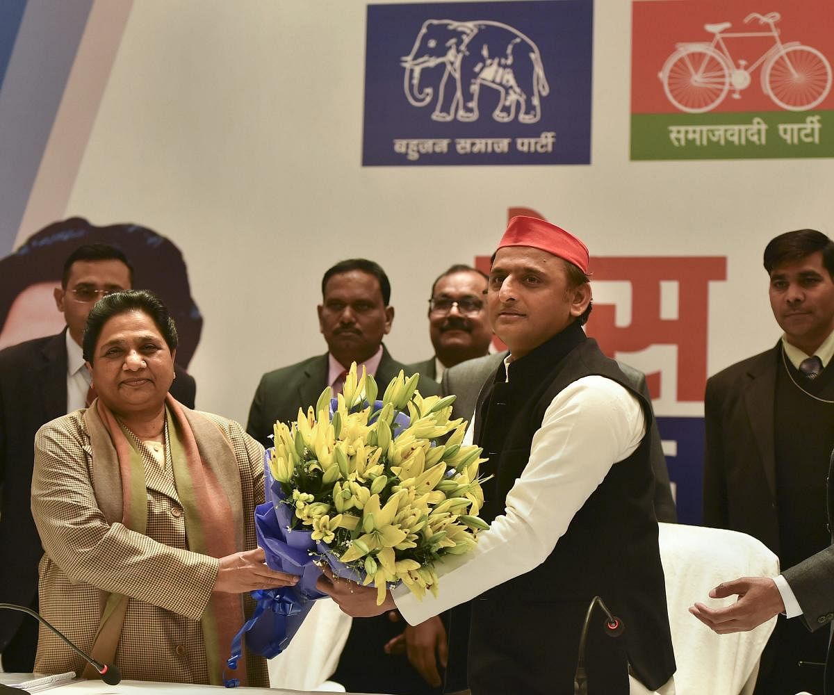BSP supremo Mayawati being greeted with a bouquet by Samajwadi Party chief Akhilesh Yadav during a joint press conference in Lucknow. (PTI Photo)