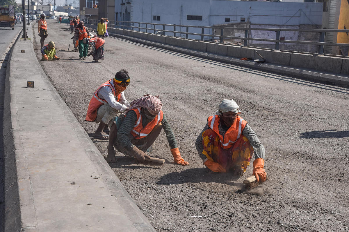 BBMP Workers busy in resurfacing work on Sri Bala Gangadharanatha Swamiji Flyover Road (Srisi circle flyover) in Bengaluru on Thursday. Photo by S K Dinesh