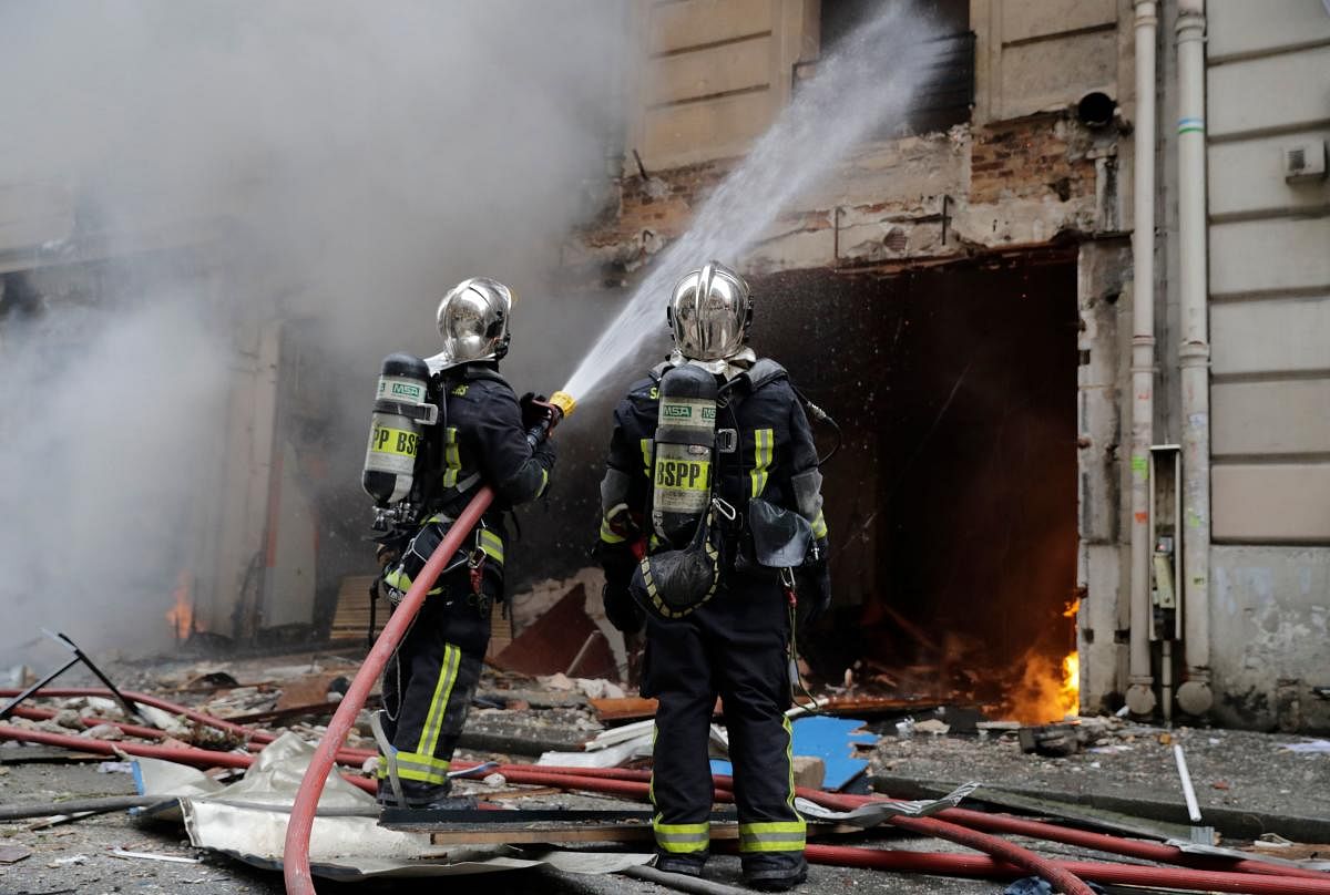 Firefighters extinguish a fire after the explosion of a bakery on the corner of the streets Saint-Cecile and Rue de Trevise in central Paris on January 12, 2019. - A large explosion badly damaged a bakery in central Paris on January 12, injuring several p