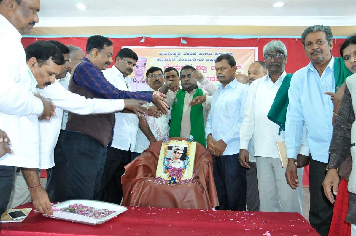 Backward Classes Commission former chairman C S Dwarakanath and others pay floral tributes to a portrait of late IPS officer K Madhukar Shetty, in Chikkamagaluru on Saturday.