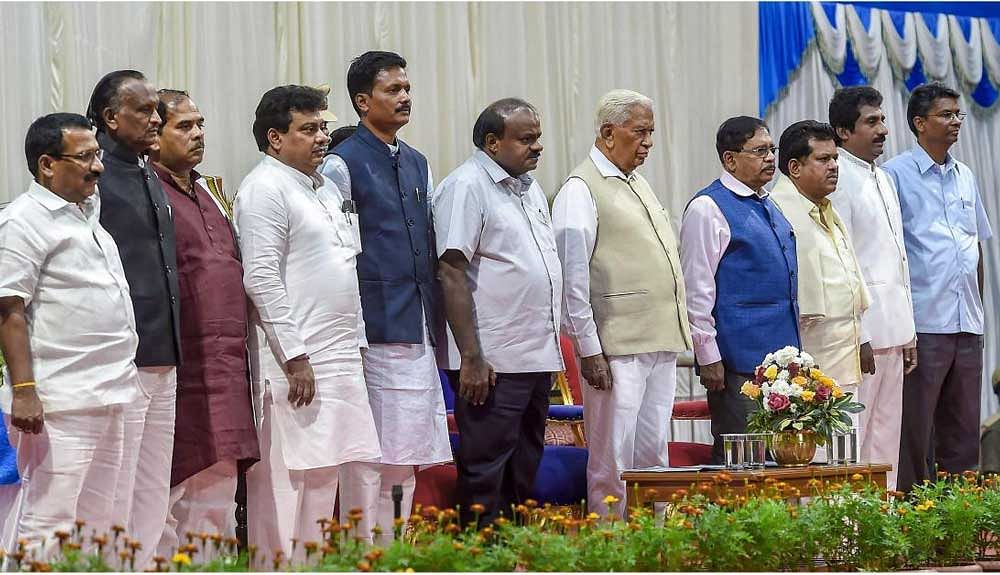 Governor Vajubhai Vala, Chief Minister H D Kumaraswamy and Deputy Chief Minister G Parameshwara with newly inducted ministers (from left), R B Thimmapur, ‘MTB’ Nagaraj, C S Shivalli, M B Patil, E Tukaram, P T Parameshwar Naik, Rahim Khan and Satish Jarkiholi at Raj Bhavan on Saturday. PTI Photo