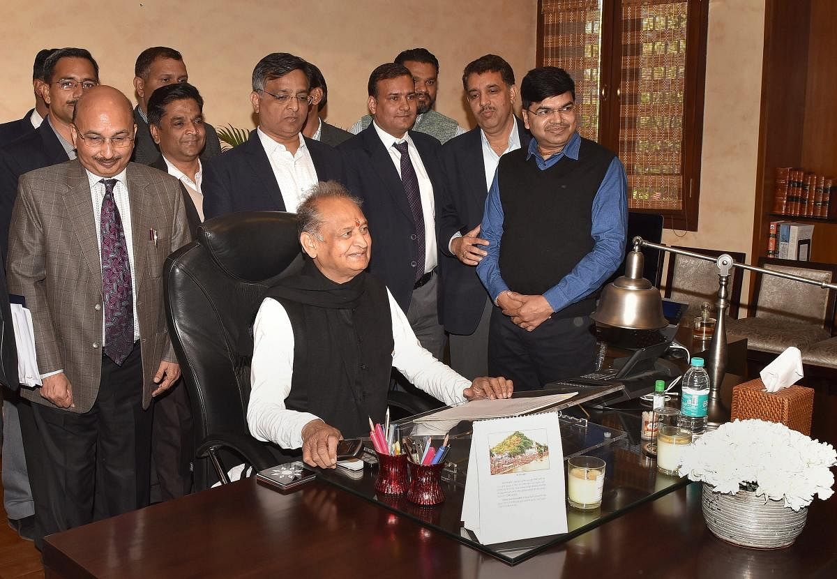 Newly-elected Rajasthan Chief Minister Ashok Gehlot poses for a photo with CMO officials in Jaipur. (PTI Photo)
