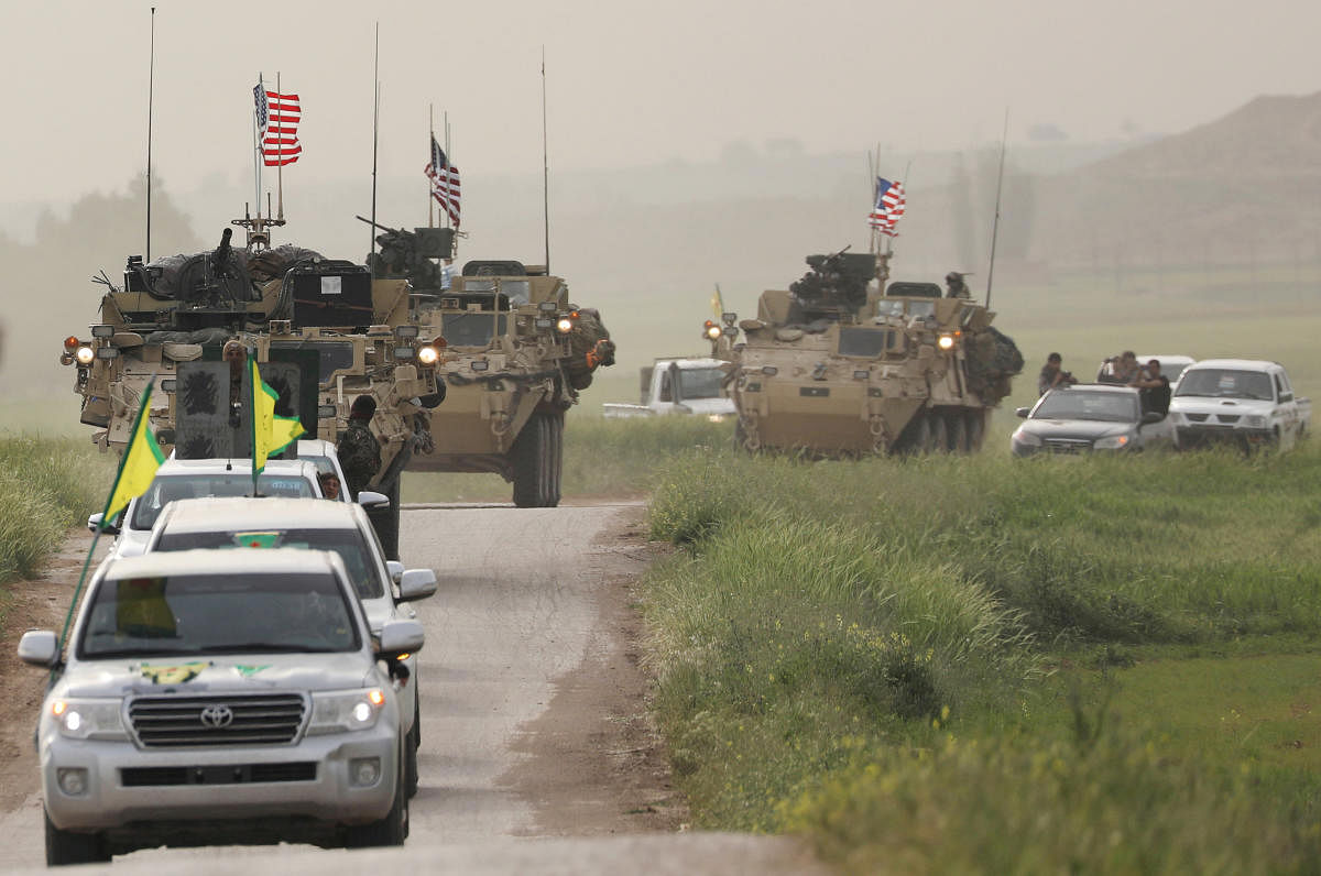 Kurdish fighters from the People's Protection Units (YPG) head a convoy of U.S military vehicles in the town of Darbasiya next to the Turkish border, Syria. Reuters file photo