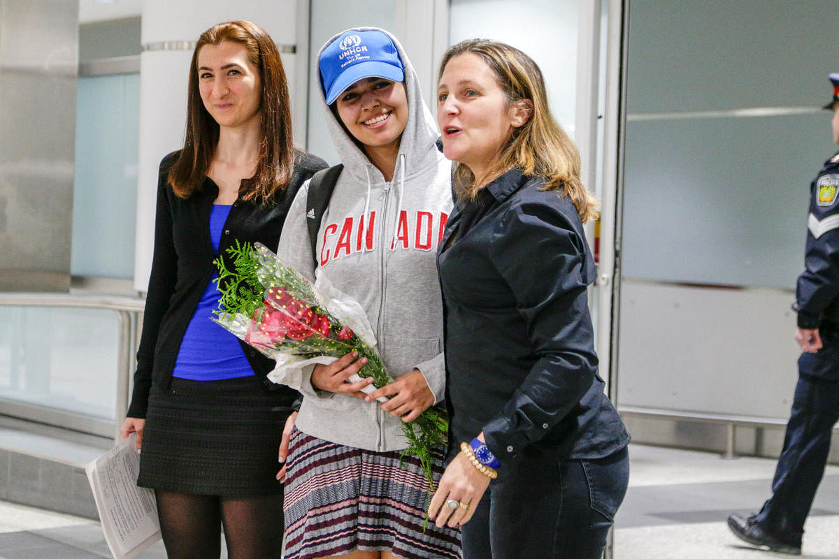 Rahaf Mohammed al-Qunun (C) accompanied by Canadian Minister of Foreign Affairs Chrystia Freeland (R) and Saba Abbas, general counsellor of COSTI refugee service agency, arrives at Toronto Pearson International Airport in Toronto. Reuters
