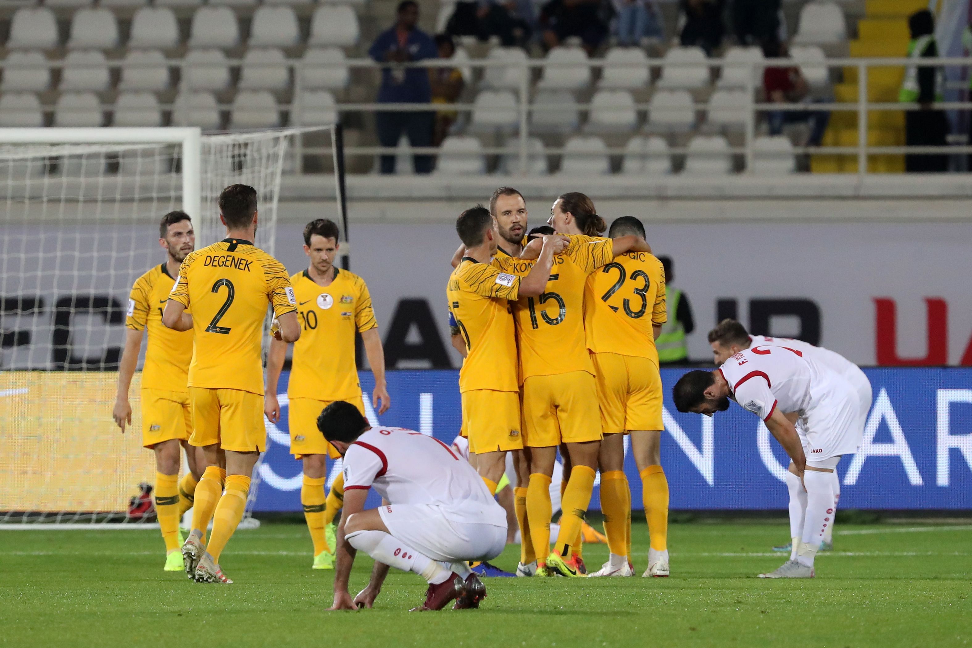 Australian players celebrate their march into the AFC Cup quarterfinals while the Syrians (in white) are downcast after exiting in the group stage. AFP