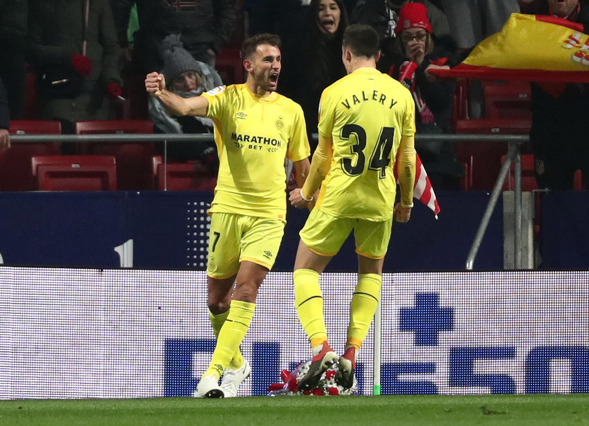 Girona's Cristhian Stuani celebrates with team-mate Valery Fernandez after scoring against Atletico Madrid on Wednesday. REUTERS