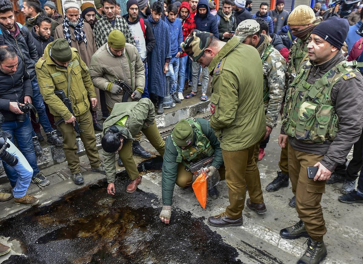 Police personnel collect samples after a grenade attack by militants who were reportedly targeting a CRPF picket, at City Centre Lal Chowk in Srinagar, Friday, Jan 18, 2019. (PTI Photo)