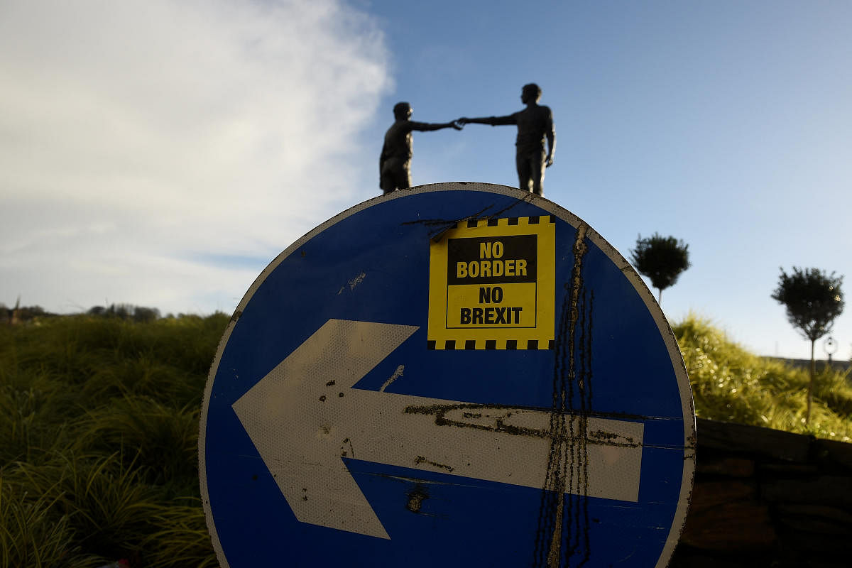 A ' No Border, No Brexit' sticker is seen on a road sign in front of the Peace statue entitled 'Hands Across the Divide' in Londonderry, Northern Ireland. Reuters Photo 