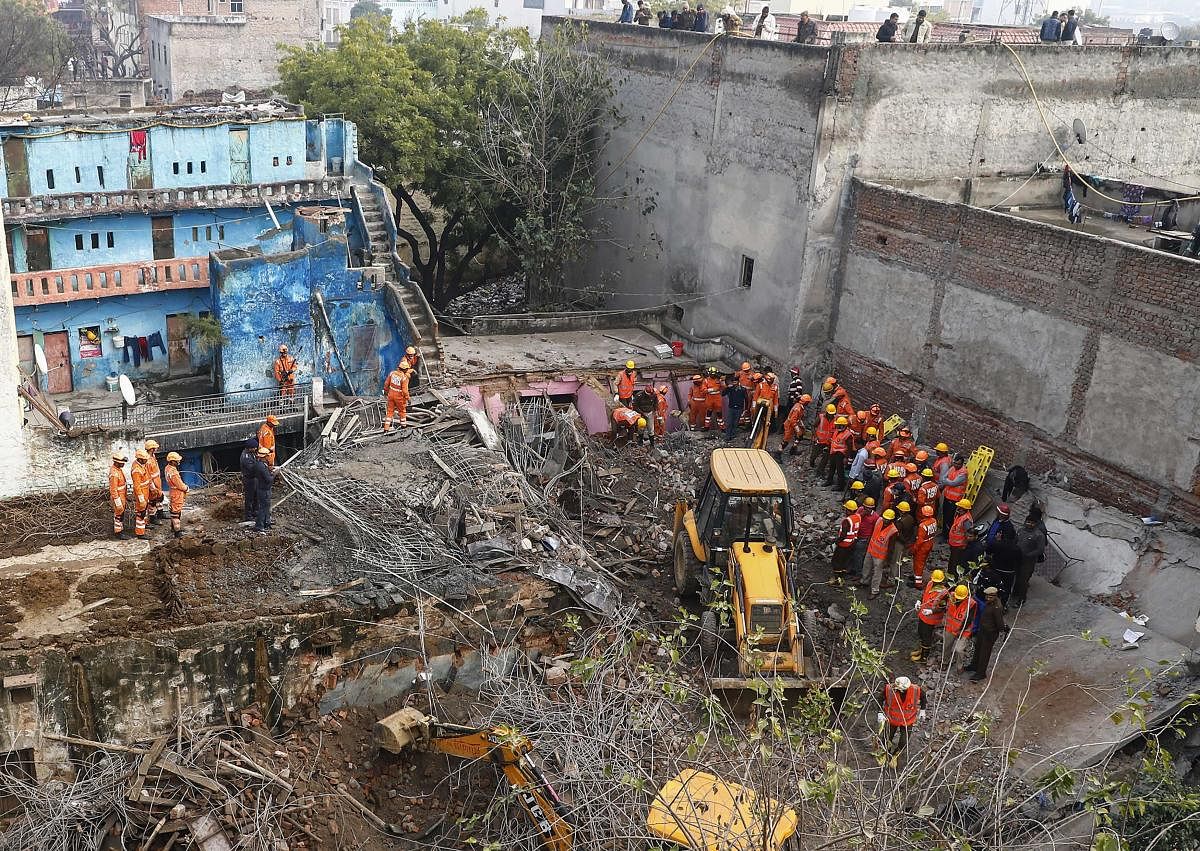 Rescue workers gather around the site of a newly constructed building that collapsed in Gurgaon, south of the Indian capital New Delhi. AFP Photo 