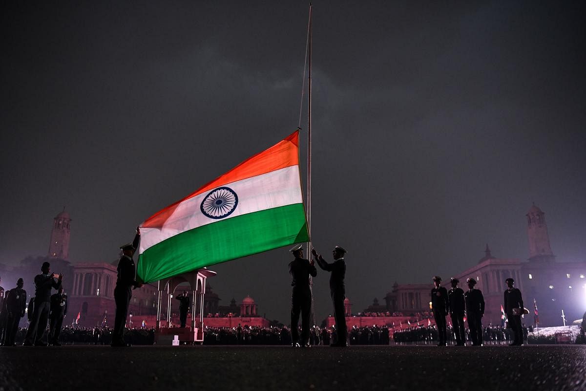 Indian Army personnel lower India's national flag during the rehearsal at the Beating Beating Retreat Ceremony at Vijay Chowk in New Delhi on January 24, 2019. - The ceremony is a culmination of Republic Day celebrations and dates back to the days when troops disengaged themselves from battle at sunset. (Photo by CHANDAN KHANNA / AFP)