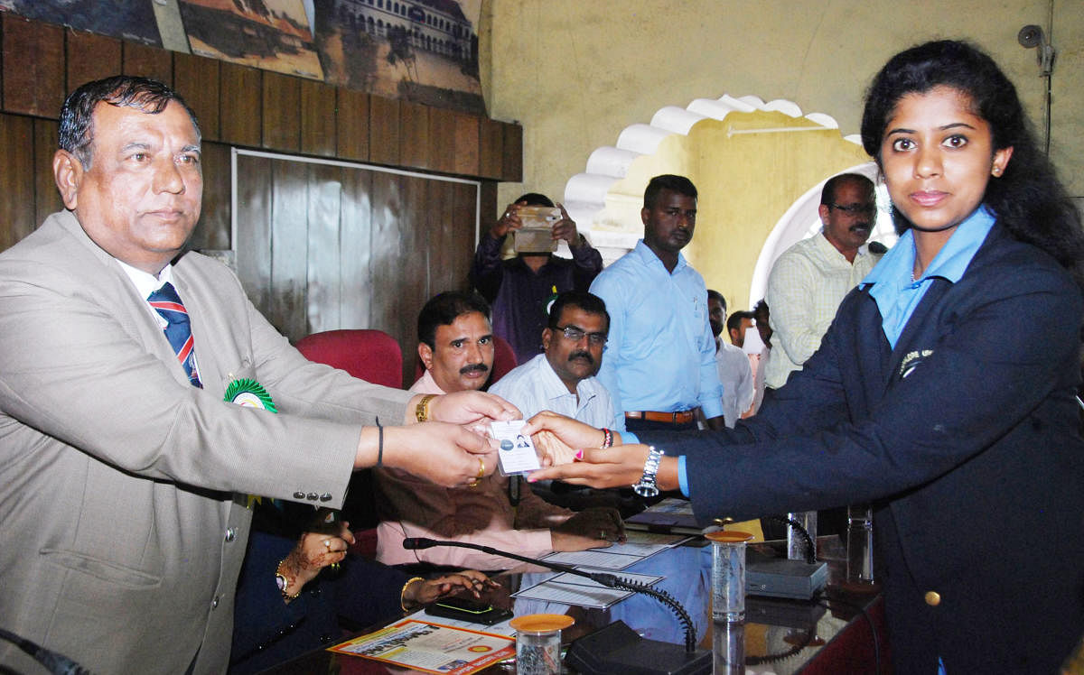 A first-time voter is given a voter identity card during the National Voters’ Day programme in Madikeri.