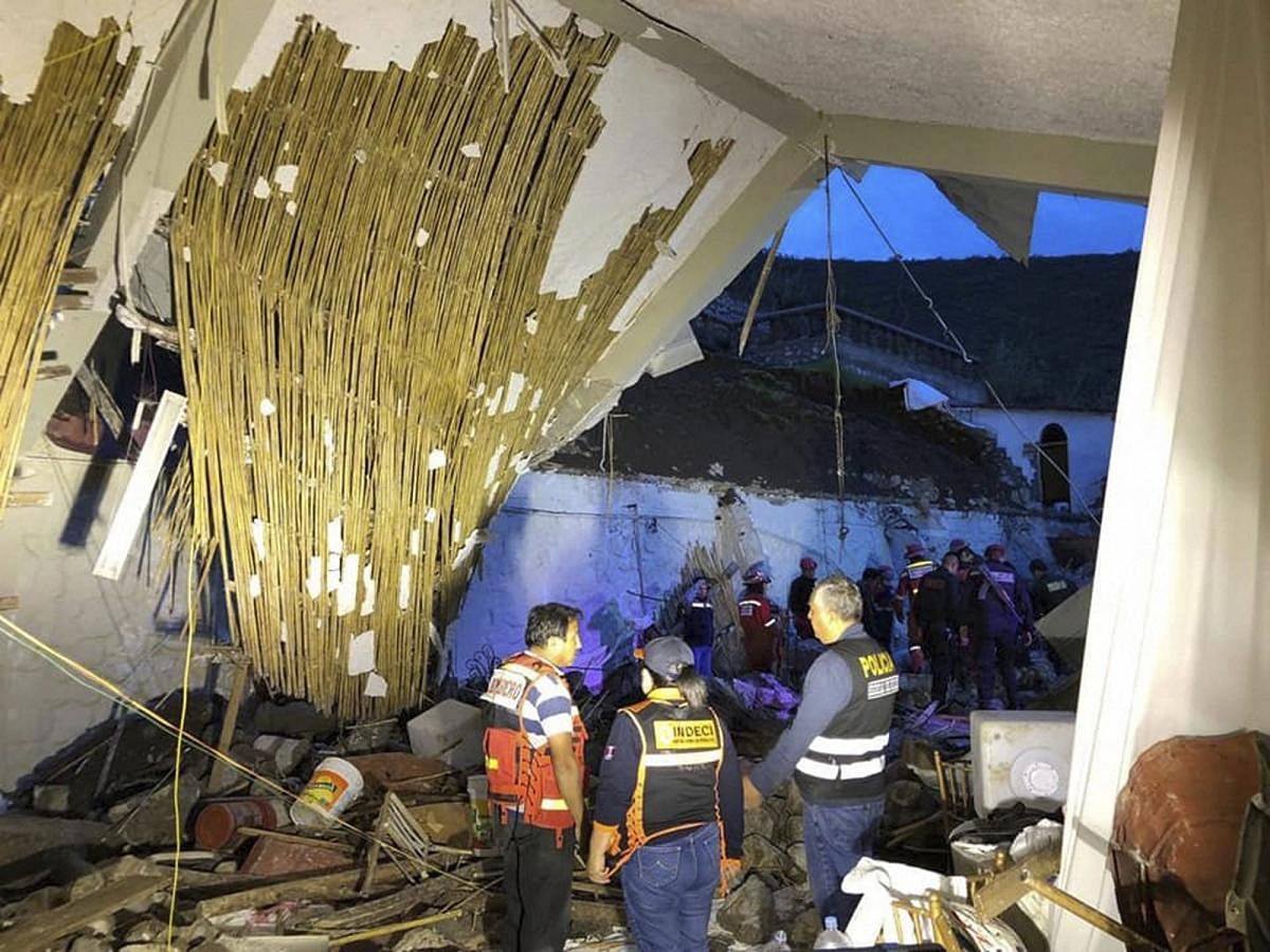 In this photo provided by Abancay police, officers and firefighters stand by a collapsed area of the Alhambra hotel in Abancay, Peru. Civil defence officials say the hotel wall collapsed during a wedding celebration, killing at least 15 people. (AP/PTI Ph