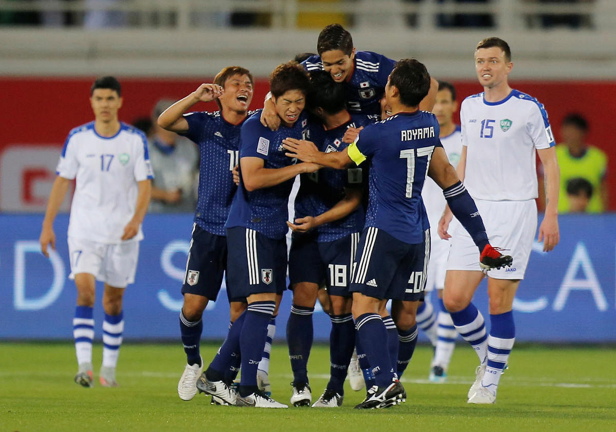 Japan players celebrate after scoring against Uzbekistan in their Group F game on Thursday. REUTERS