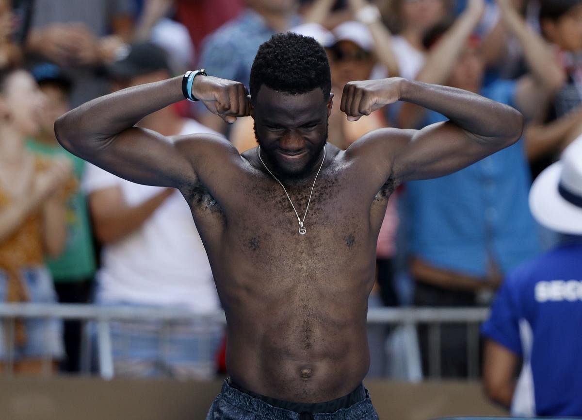 Frances Tiafoe celebrates his win over Bulgaria's Grigor Dimitrov by showing off his muscles to the delight of the crowd. REUTERS