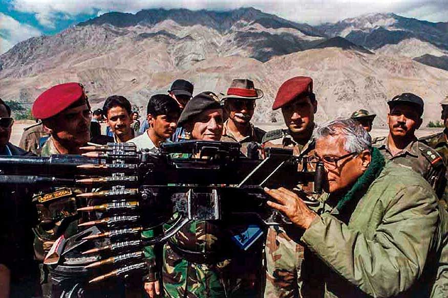 George Fernandes taking a view through a heavy machine gun, seized from the Pakistan army in Kargil. (Image: PTI)