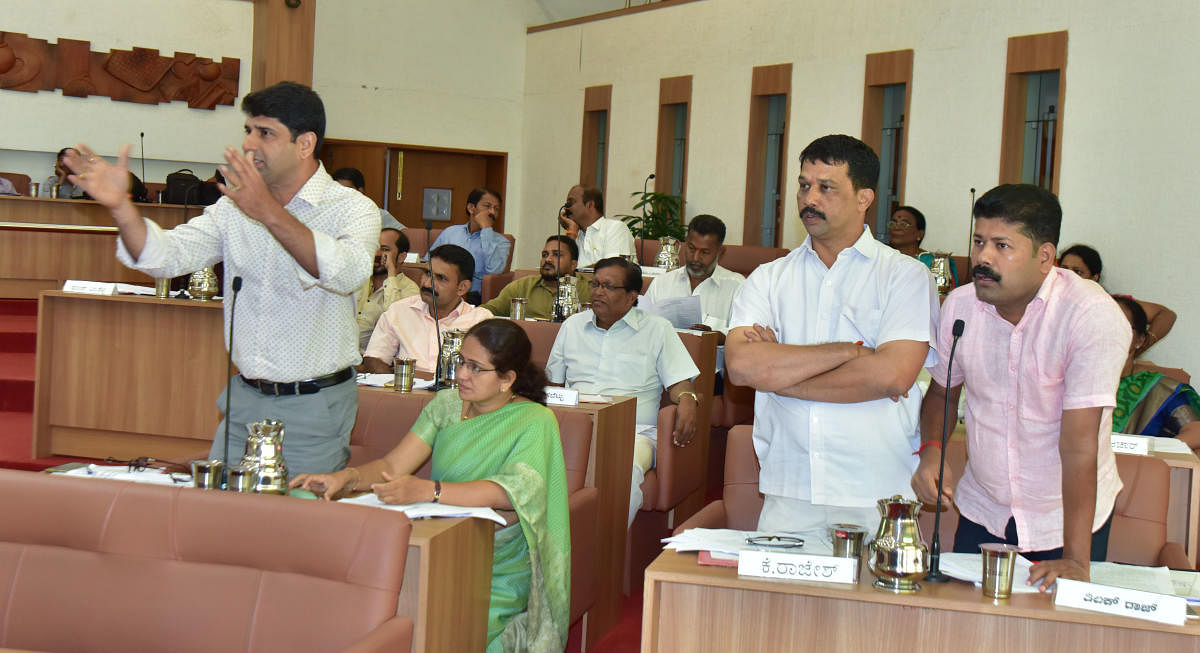 Mangaluru City Corporation Opposition leader Premanand Shetty and others raise the topic of the G+3 housing scheme at the MCC general meeting on Wednesday.