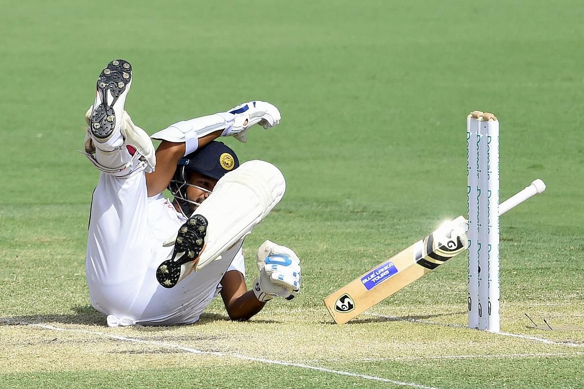 Sri Lanka's Dimuth Karunaratne falls to the ground after being hit by a Pat Cummins bouncer on Saturday. AFP