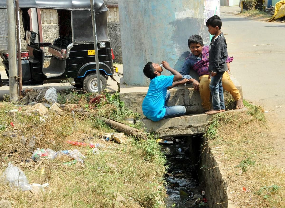 Children play beside a drain in Chikkamagaluru.