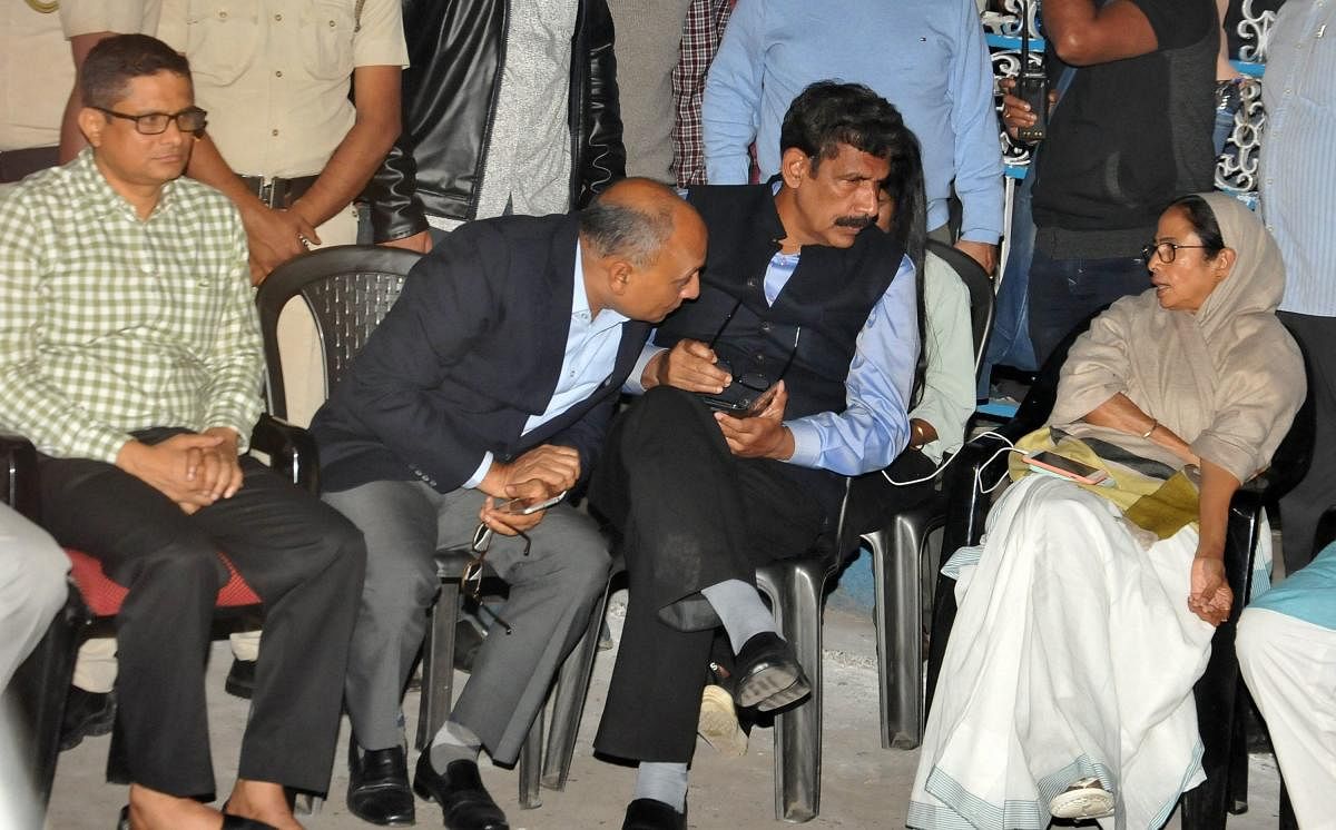 West Bengal Chief Minister Mamata Banerjee sitting on her 'Save the Constitution' dharna after CBI raids Kolkata Police Commissioner's residence in Kolkata, Sunday late evening, Feb 03, 2019. Kolkata Police Commissioner Rajeev Kumar (L) is also seen. (PTI