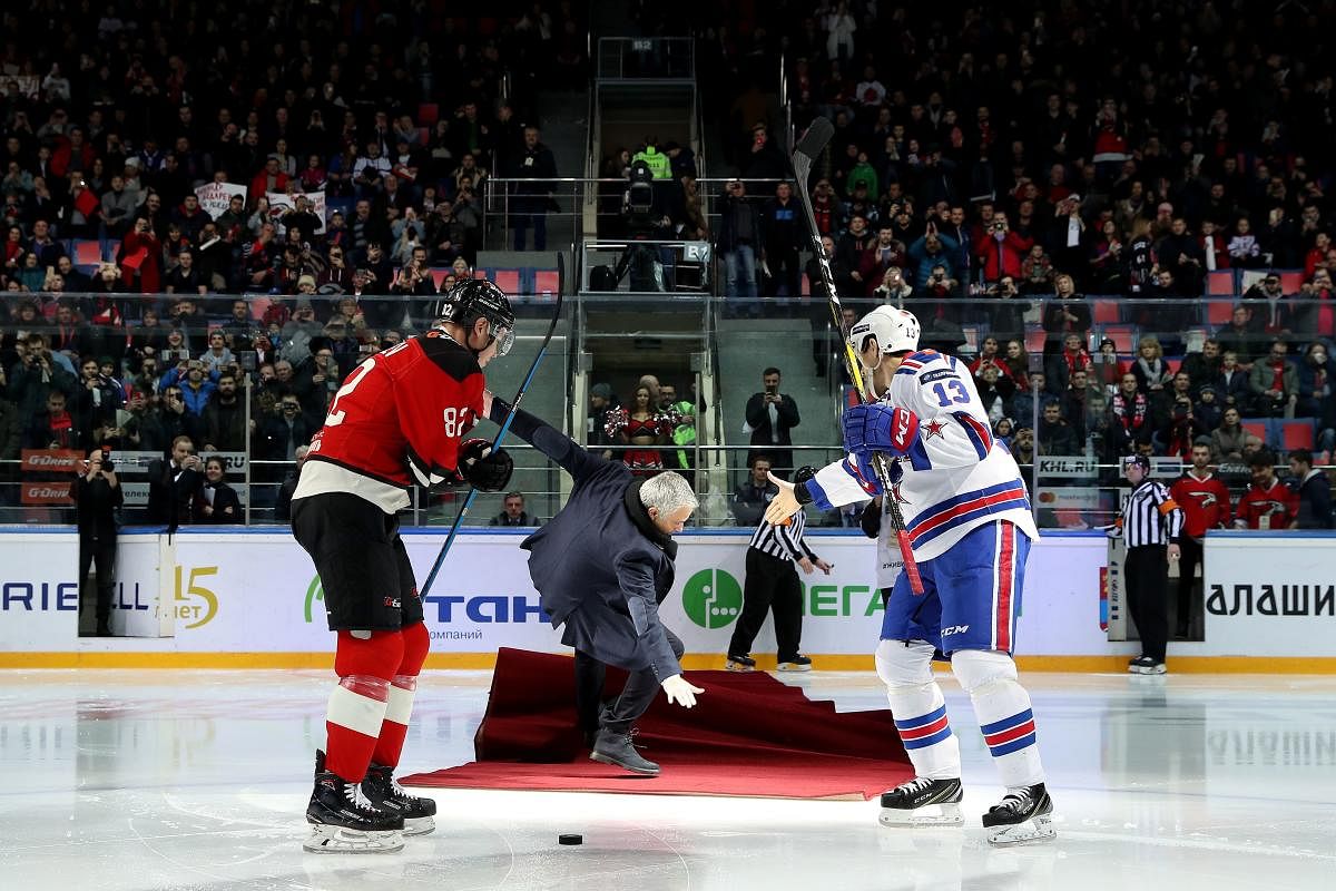 Former Manchester United manager Jose Mourinho (centre) falls as he drops the puck to start a Continental hockey league match between Avangard Omsk and SKA Saint Petersburg in Balashikha. AFP