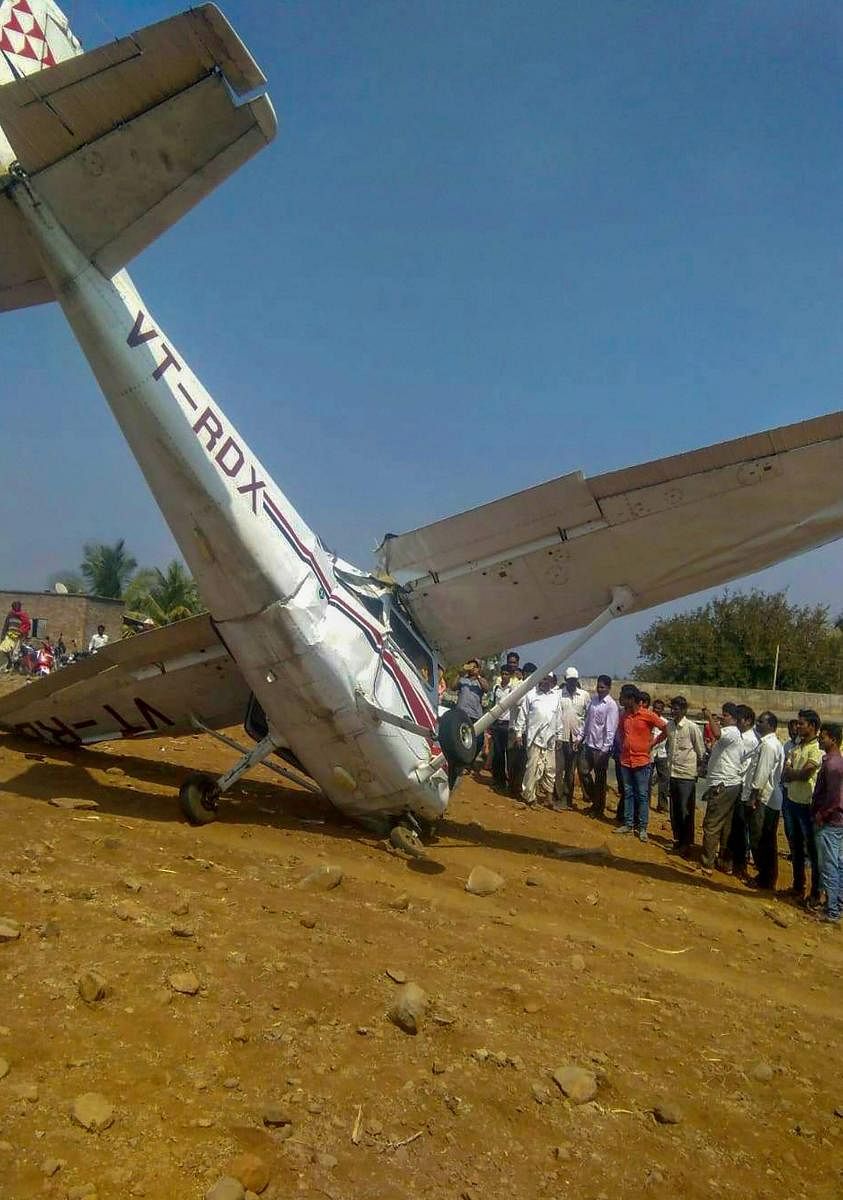 People look at the wreckage of a crashed aircraft, which was being used for civil aviation training, in Pune district, Tuesday, Feb. 5, 2019. (PTI Photo)