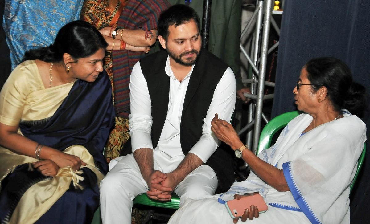 West Bengal Chief Minister Mamata Banerjee with DMK MP Kanimozhi (L) and RJD leader Tejashwi Yadav at Banerjee's sit-in over the CBI attempt's to question the Kolkata Police Commssioner in connection with chit funds scam, in Kolkata, on February 4, 2019.
