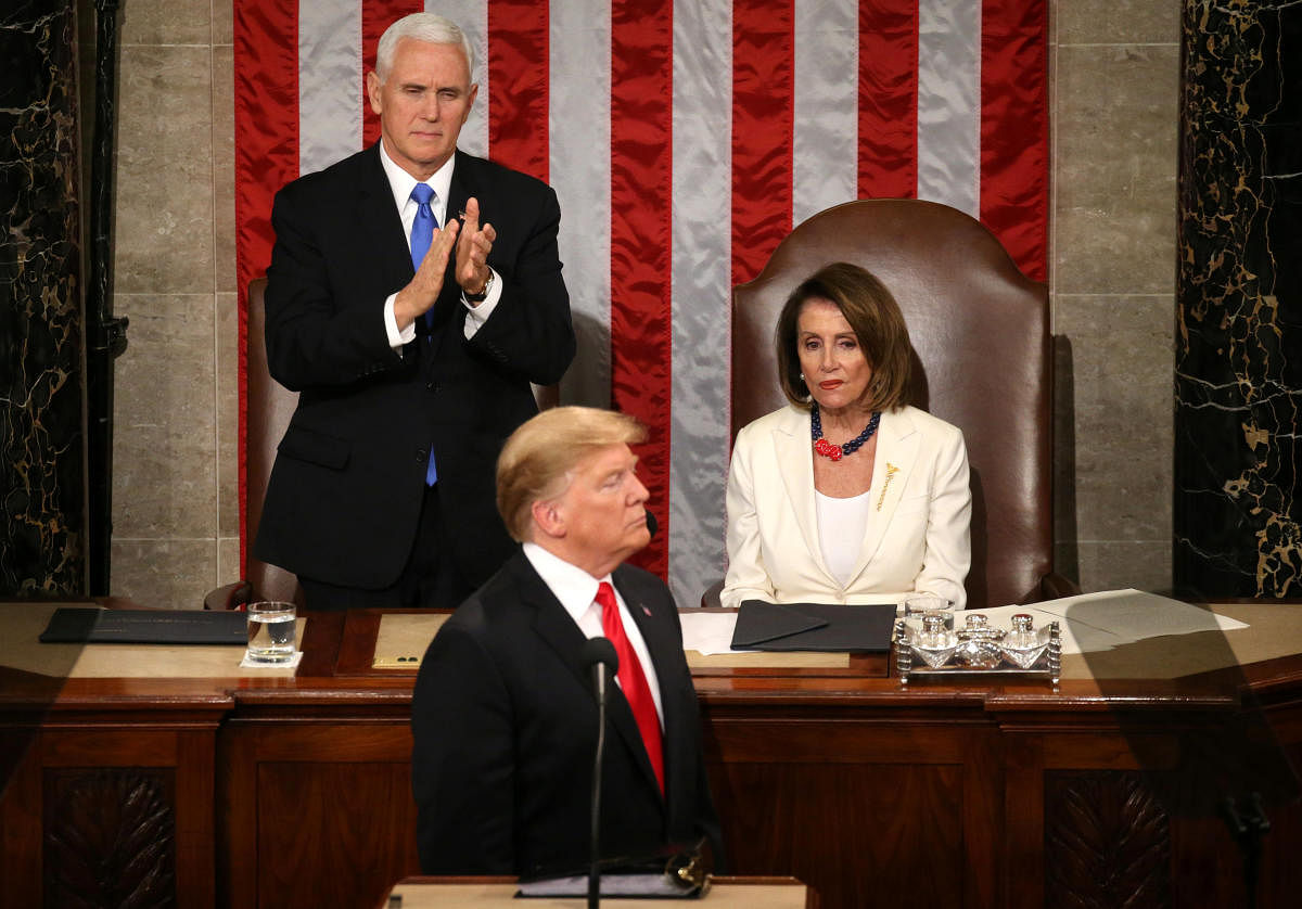 Speaker of the House Nancy Pelosi (D-CA) reacts alongside Vice President Mike Pence as he applauds U.S. President Donald Trump during his second State of the Union address to a joint session of the U.S. Congress in the House Chamber of the U.S. Capitol on