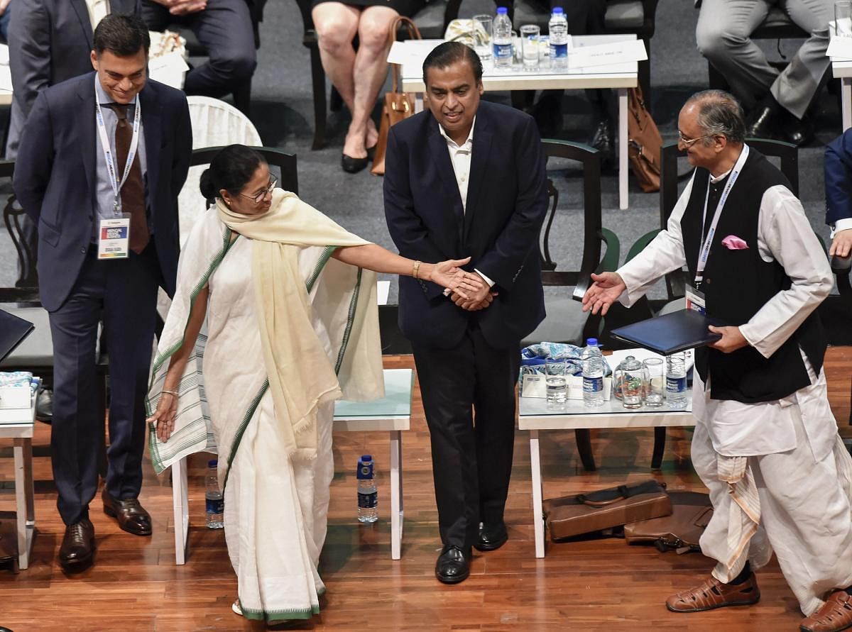 West Bengal Chief Minister Mamata Banerjee gestures at State Finance Minister Amit Mitra as Reliance Industries Chairman Mukesh Ambani and JSW Group Chairman Sajjan Jindal (L) look on, during 'Bengal Global Business Summit 2019' in Kolkata on Thursday. PT