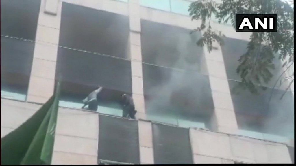 Thick smoke could be seen billowing out of the building in Sector 12. People were standing on ledges in balconies as rescuers tried to reach them by breaking window panes. (Image: ANI/Twitter)