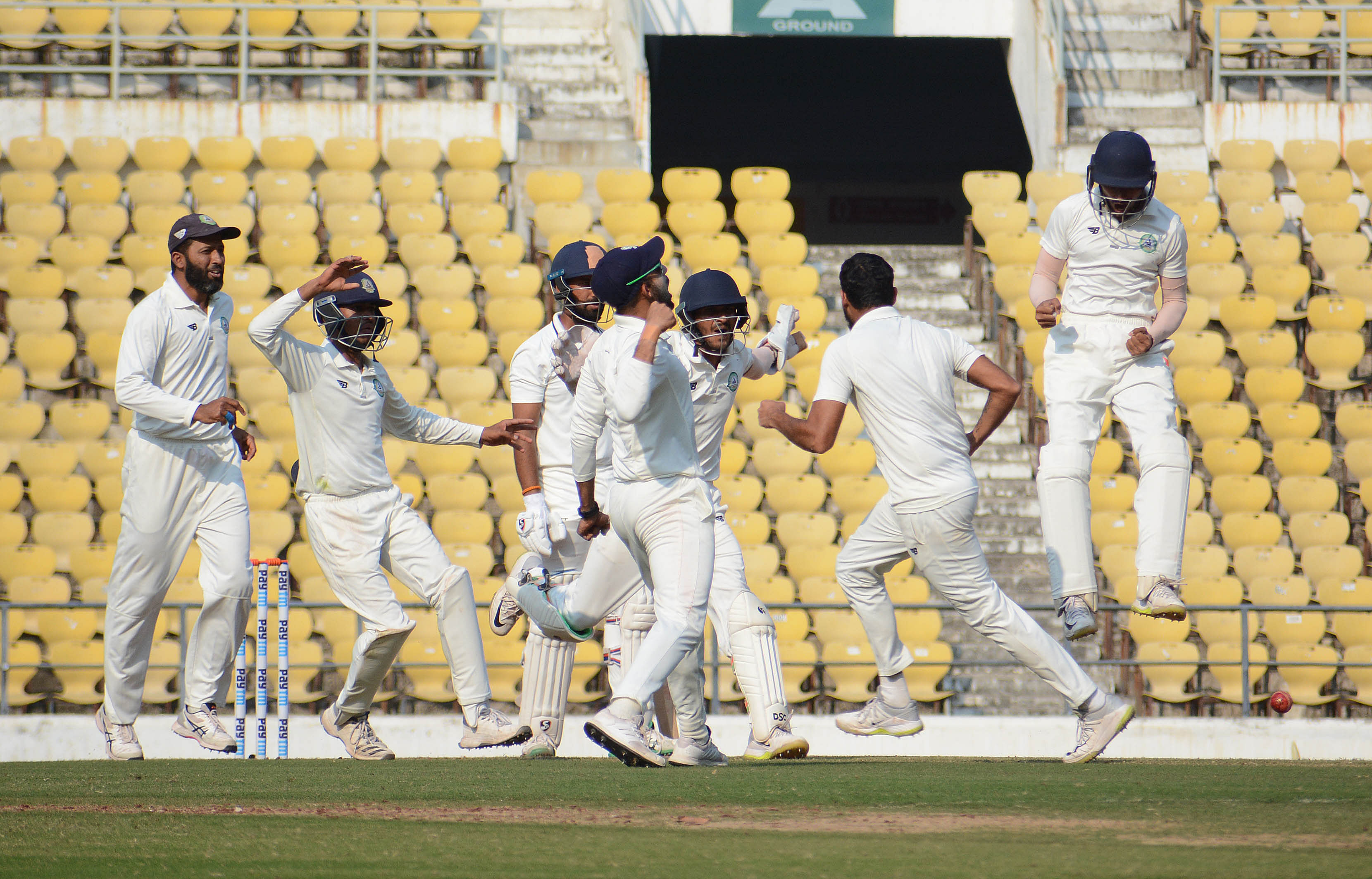 Vidarbha players celebrate the dismissal of Saurashtra's Cheteshwar Pujara on the fourth day at VCA Jamtha Stadium. 