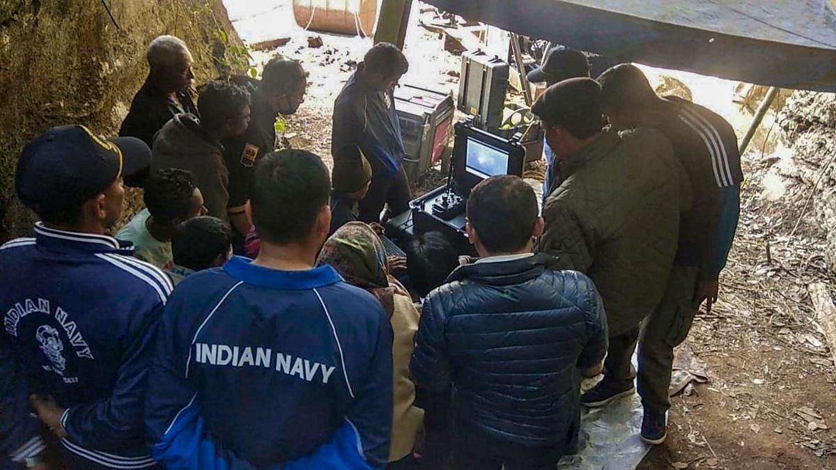 Naval divers look at the captured pictures of one of the 15 miners trapped in illegal rat mines since December 13, in Ksan area of East Jaintia Hills, on January 17, 2019. PTI