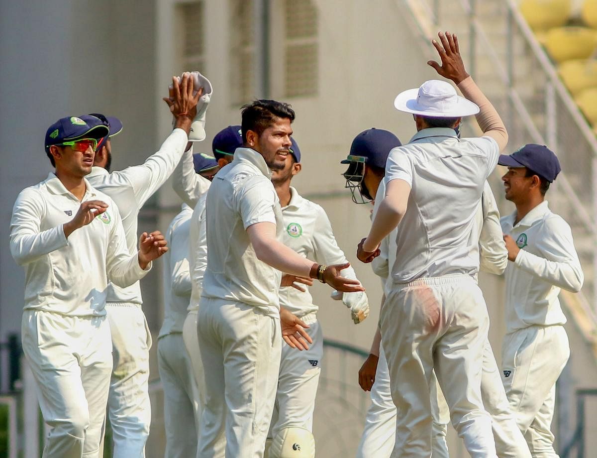 Vidarbha's Umesh Yadav celebrates with team-mates after taking the wicket of Saurashtra batsman Snell Patel during the third day of the Ranji Trophy Final in Nagpur. PTI