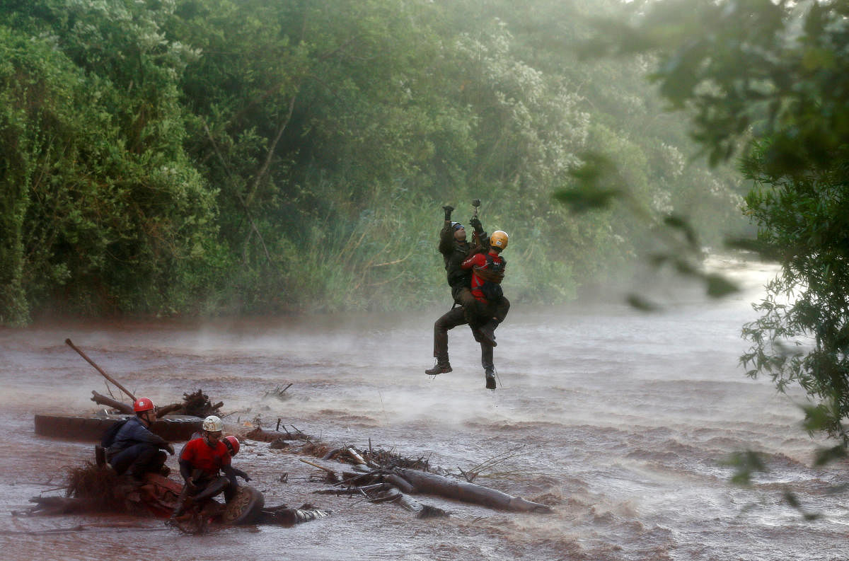A soldier helps a member of a rescue team on Paraopeba River as they search for victims of a collapsed tailings dam owned by Brazilian mining company Vale SA, in Brumadinho, Brazil February 5, 2019. REUTERS