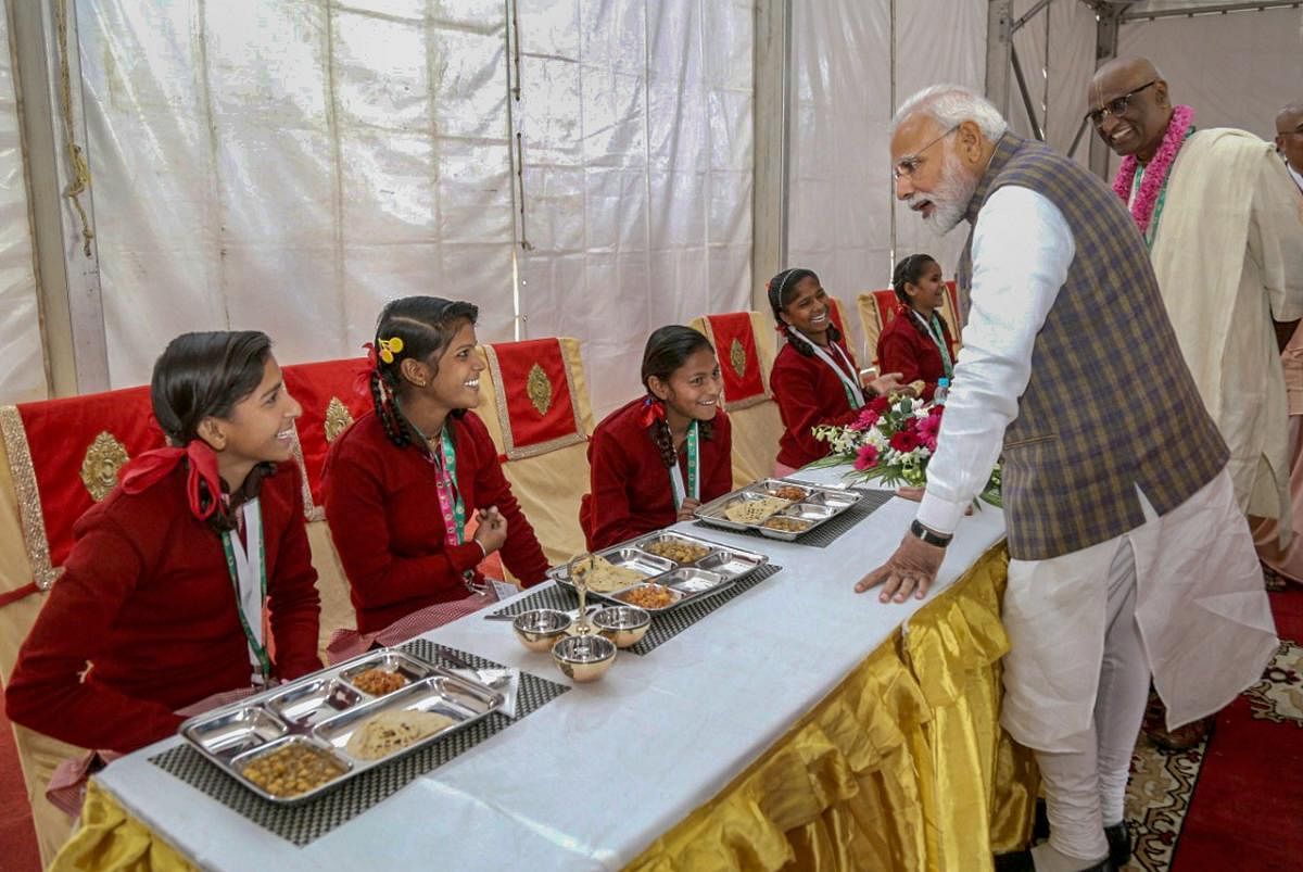 Prime Minister Narendra Modi serves food to underprivileged children during a programme organised to mark the serving of the 3rd billionth meal by the Akshaya Patra Foundation, in Vrindavan near Mathura, on Monday. PTI