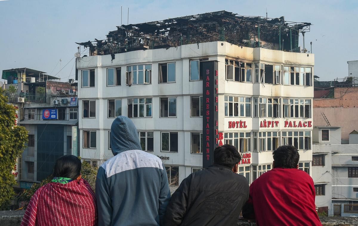 People look on at Karol Bagh's Hotel Arpit Palace where a massive fire broke out, in New Delhi, Tuesday, Feb. 12, 2019. At least 17 people were killed and several others were injured in the accident. (PTI Photo)