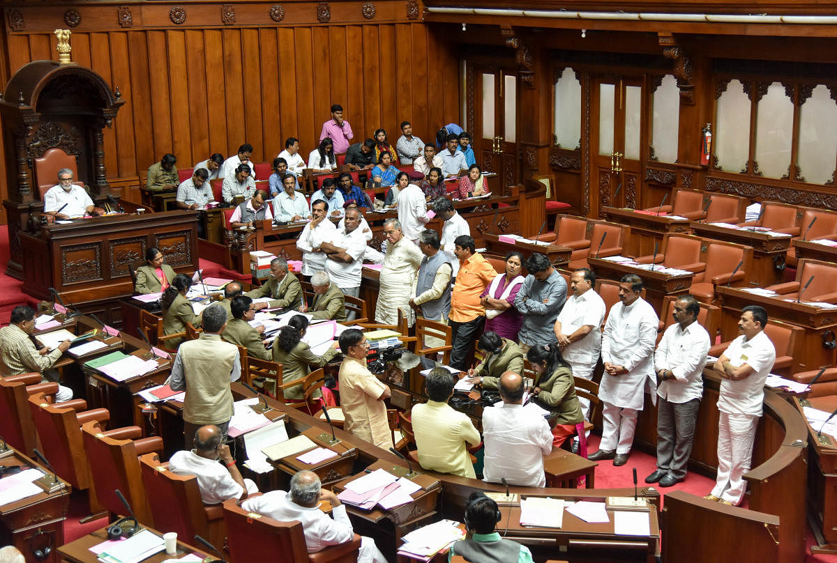 Din in Council: Opposition BJP members stage a protest against 'irregularities' in the execution of pure drinking water unit project in Legislative Council on Tuesday. DH photo