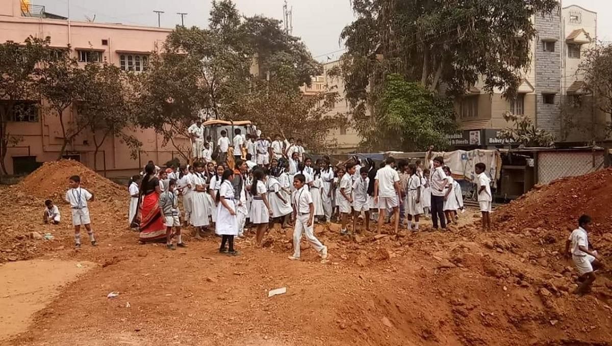 School children prevent the JCB from excavating the 40-year-old playground in Nandini Layout,  Ramakrishna Nagar, near the Rajkumar Samadhi.
