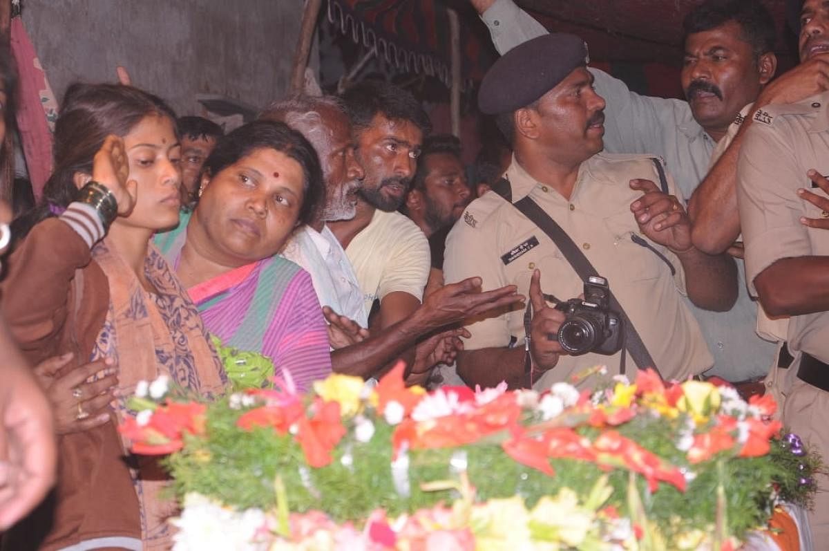 FINAL SALUTE: Kalavathy, wife of H Guru, at his coffin at Gudigere Colony in Maddur taluk, Mandya, on Saturday.