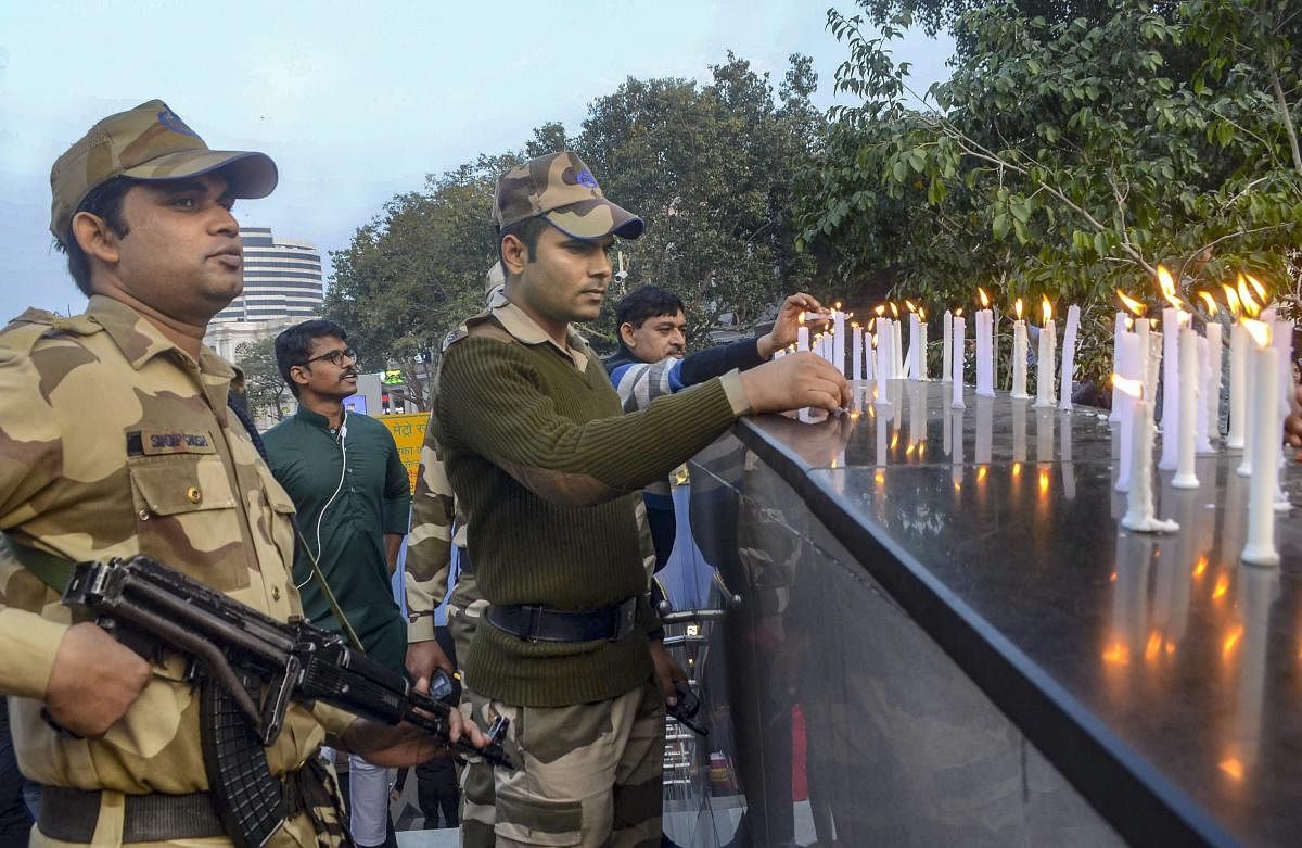 CISF members light candles to pay tribute to CRPF soldiers who lost their lives in Pulwama terror attack, at Connaught Place in New Delhi. PTI