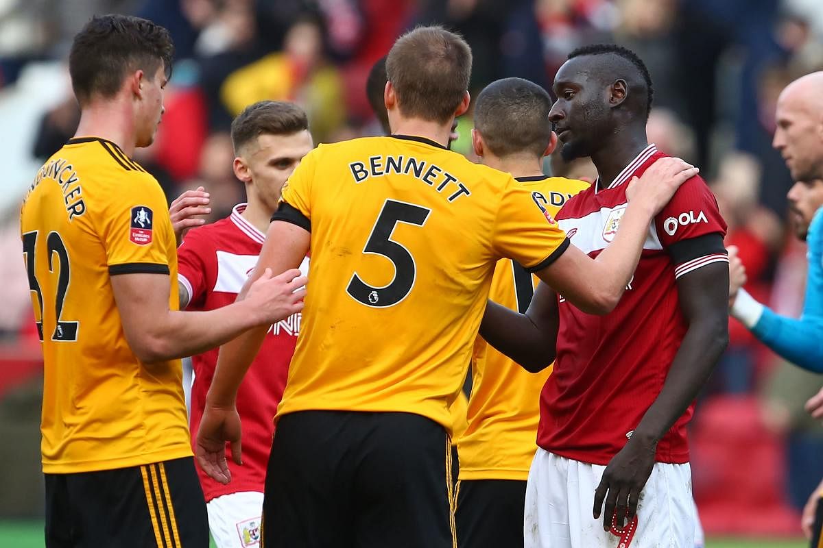 Wolverhampton Wanderers' English defender Ryan Bennett (C) consoles Bristol City's Senegalese striker Famara Diedhiou (R) on the pitch after the English FA Cup fifth round football match between Bristol City and Wolverhampton Wanderers at Ashton Gate Stad