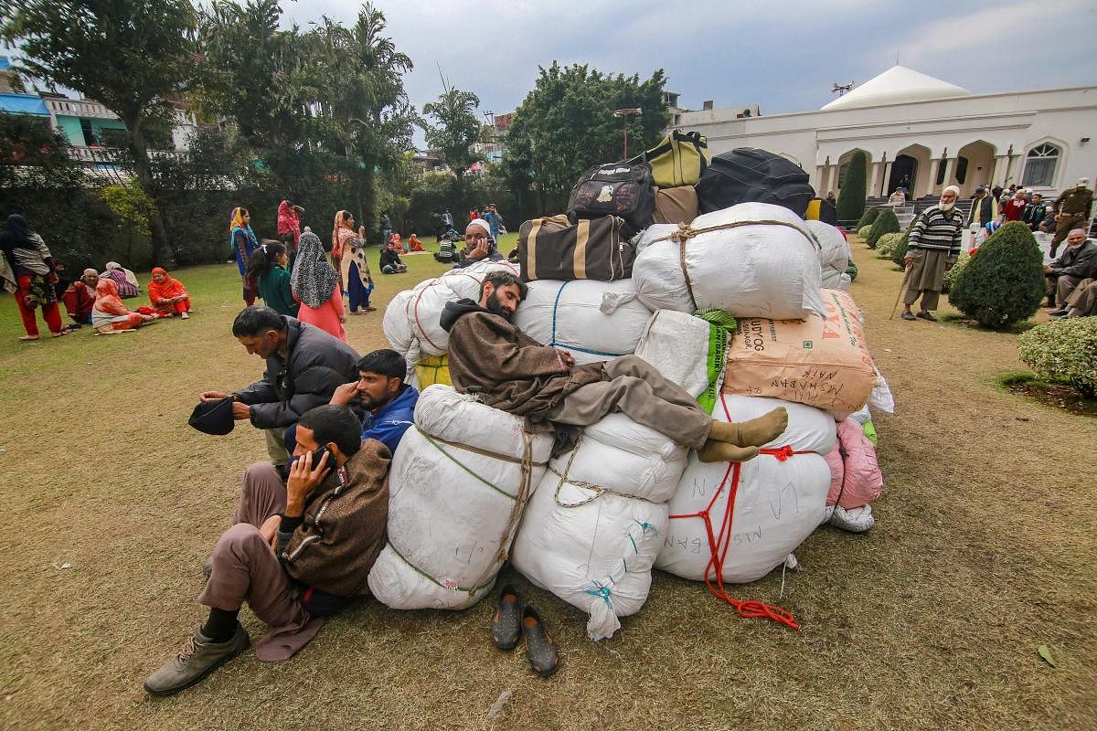 Stranded Kashmiri passengers rest as they wait for the highway to open at Makka Masjid in Bhatindi area of Jammu, Monday, Feb 18, 2019. The curfew was imposed Friday following the violent protests over the Pulwama terror attack. (PTI Photo) 