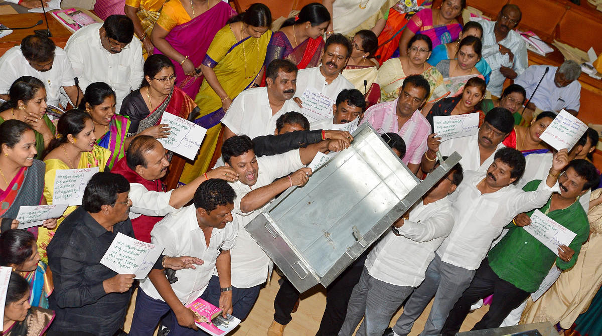 BJP councillors protest in the well of the council when S P Hemalatha, chairperson of the Standing Committee on Taxation and Finance, was presenting the budget on Monday. (DH Photo)