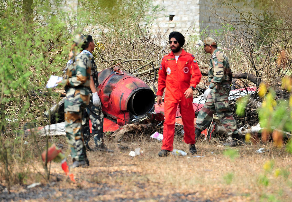 Soldiers stand near the wreckage after two Hawk aircraft of the Surya Kiran Aerobatic Display Team of the Indian Air Force collided in mid-air while rehearsing ahead of Aero India show at the Yelahanka Air Force Station in Bengaluru, India, February 19, 2