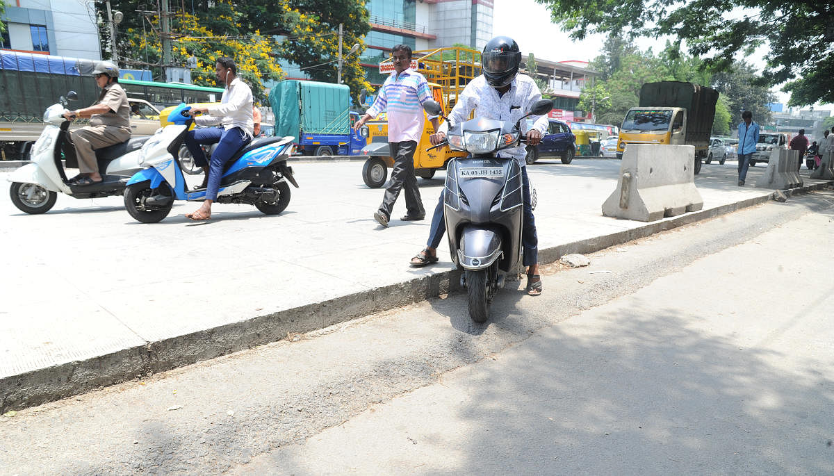 A motorist struggles to get onto the asphalted road from the half complete white-topped pavement on Mysore Road on Saturday. Photo Srikanta Sharma R.