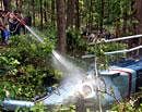Firemen spray water on the remnants of a helicopter after it crashed in Ladpur jungles near Raipur in Dehradun on Sunday. PTI