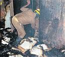 A fireman trying to salvage BBMP documents gutted in a fire at one of its offices on Sampige Road. DH Photo